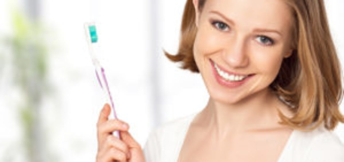 Young Woman Smiling with Toothbrush